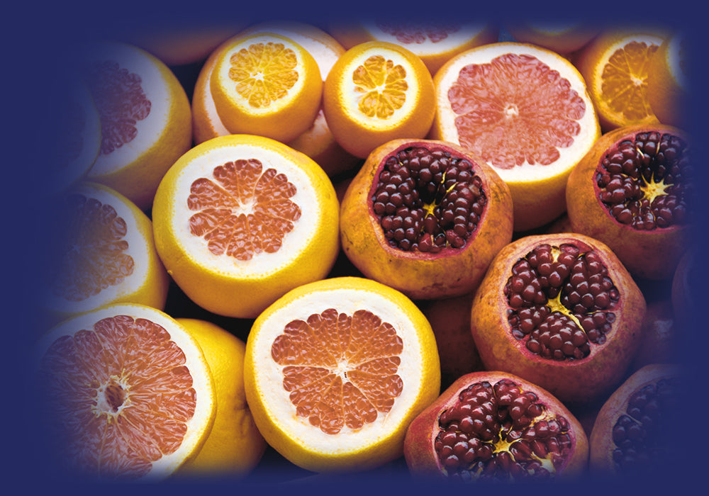 Vibrant citrus fruits and pomegranates, rich in vitamins for Pro-Fit's health focus.