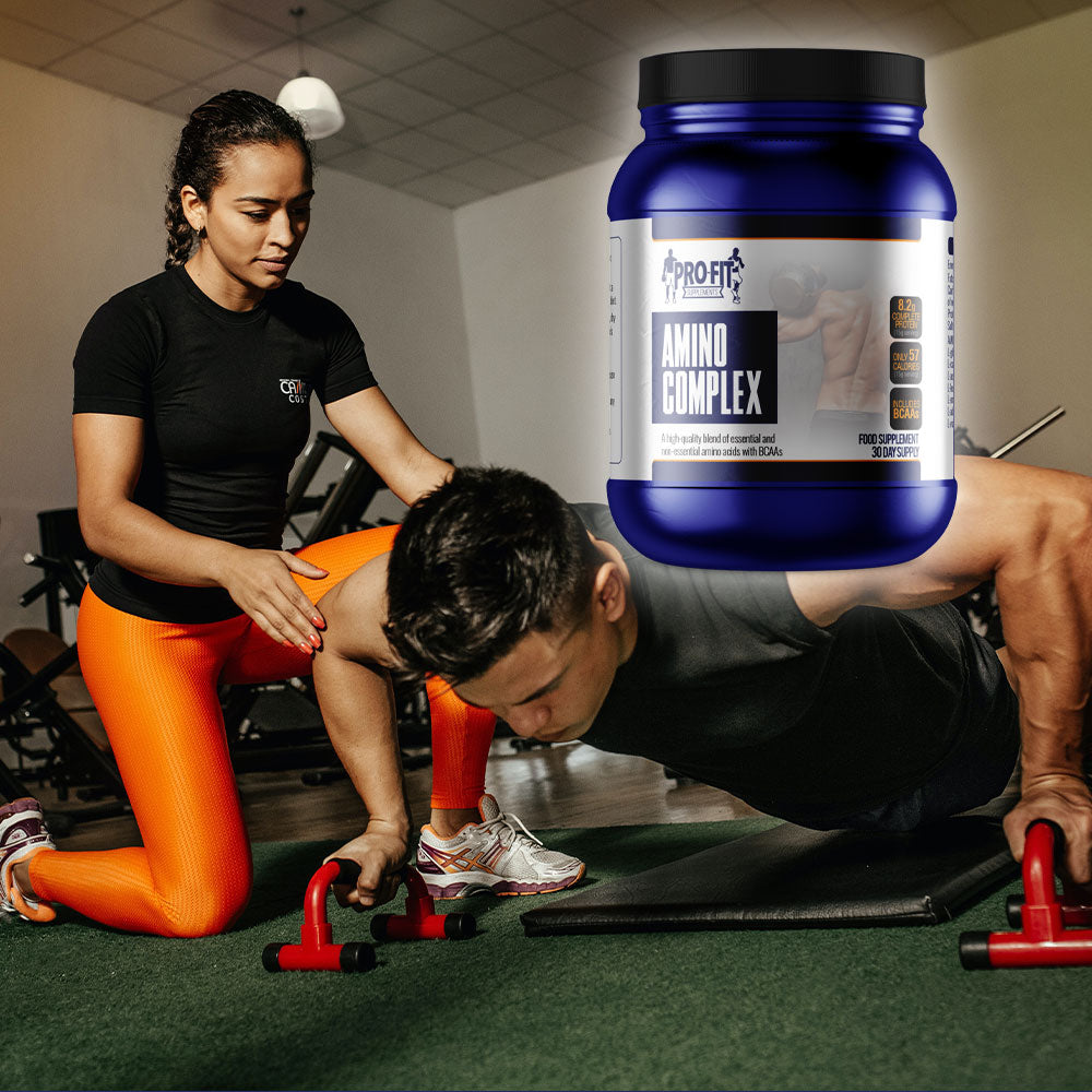 amino complex (450g) Powder next to woman helping a man in the gym doing press ups