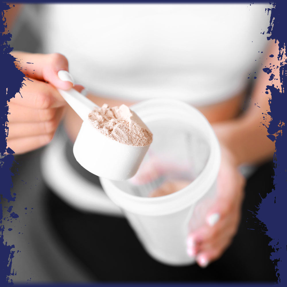 A woman adding a scoop of protein powder to a shaker bottle