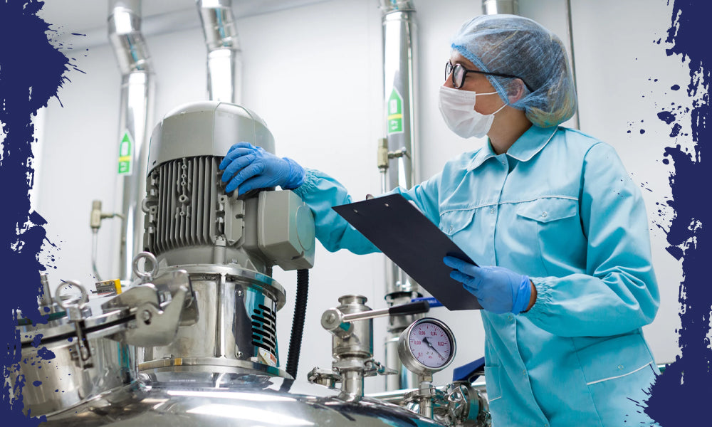 Woman in lab clothes inspecting a machine in a manufacturing plant