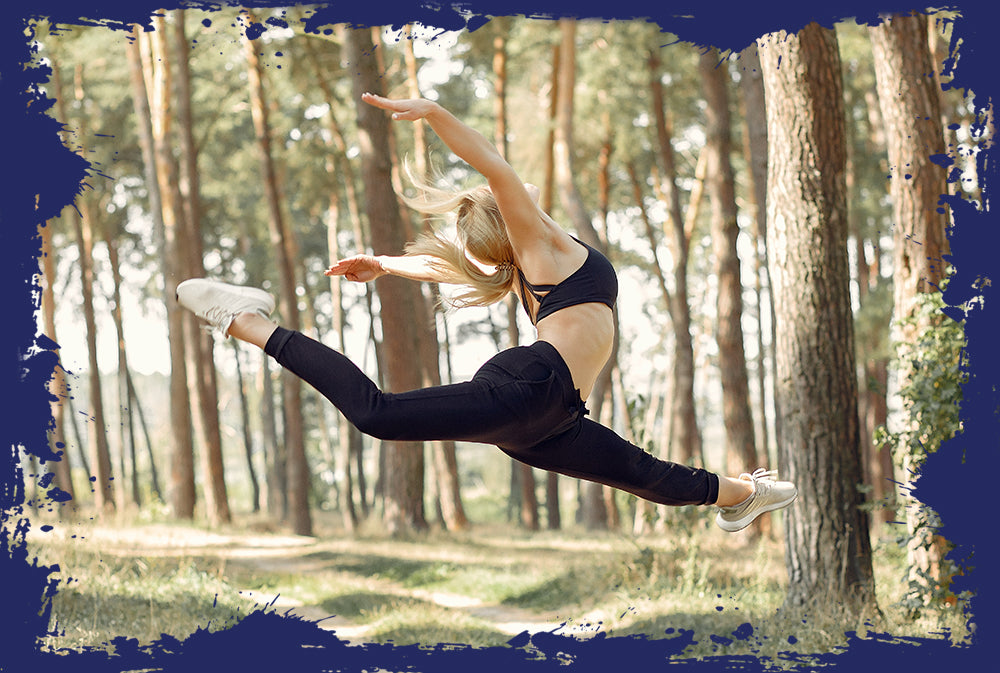 Dynamic woman mid-jump in a forest, expressing Pro-Fit's dedication to vibrant living.