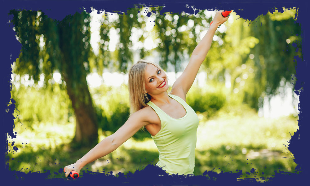 Joyful woman exercising with dumbbells in the park, aligned with Pro-Fit's holistic health.